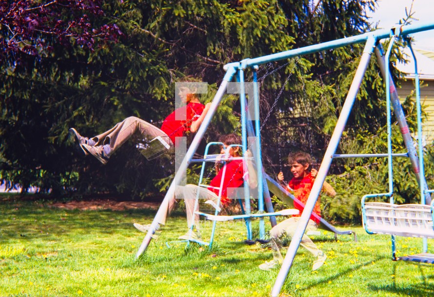 a boy on a backyard swing set