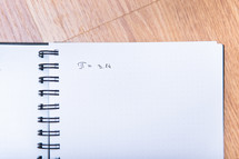 The number pi is written in a notebook with a pen. Pi day number concept. pi is 3.14
