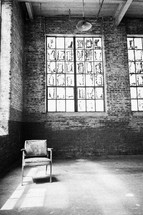 Chair in front of windows in an empty loft.