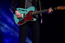 a man with a guitar on stage 