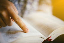 a person reading and pointing to scripture 