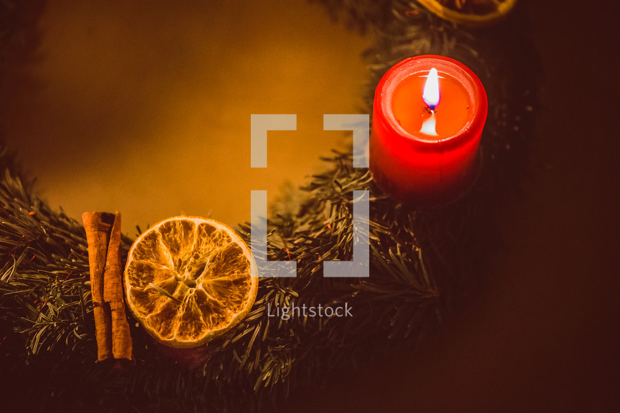 orange, cloves, greenery, and a candle Christmas scents 