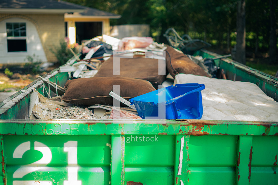 dumpster in front of a house - cleaning up after flood damage 