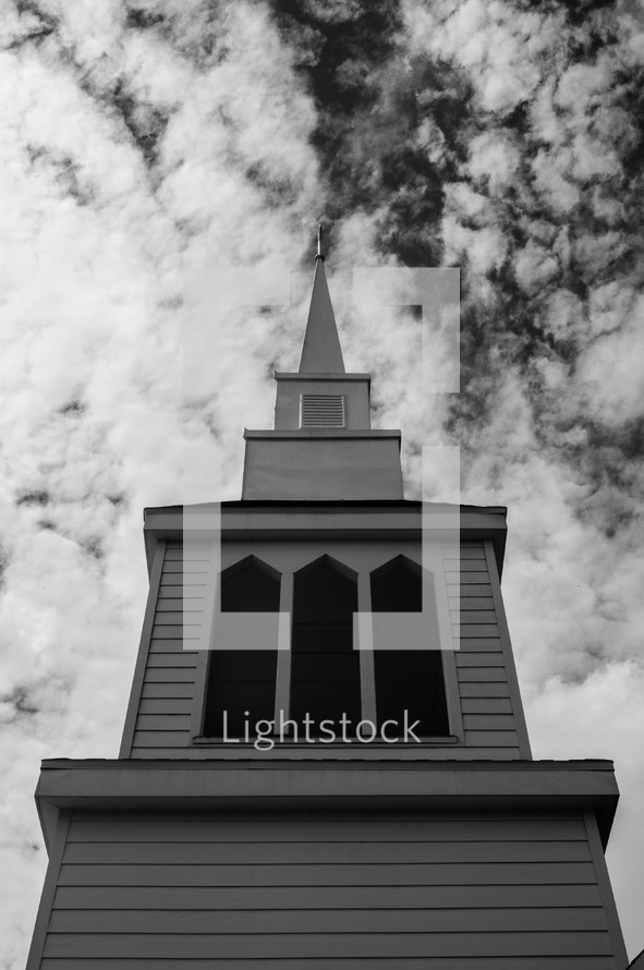 white church steeple in the clouds
