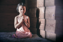 a little girl kneeling in prayer 