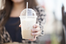 woman holding a milkshake 
