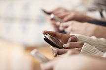 Hands texting on smart phones.