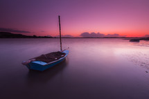 boat on calm water at sunset 