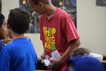 teen volunteer collecting name badges for VBS 2018