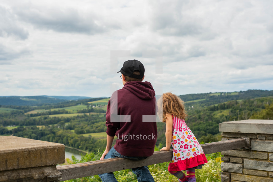 children looking out at a green landscape 