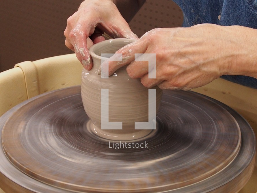 potter forming clay on a potter's wheel 