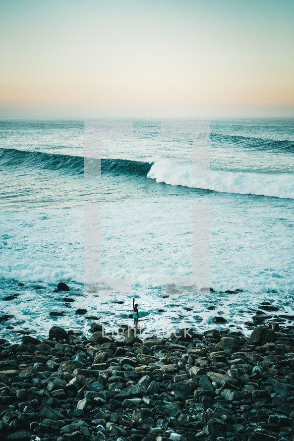 surfer standing on a shore 