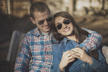 A young couple wearing sunglasses smiling together