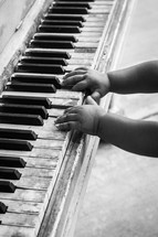 infant hands on an old piano 