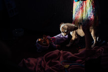 sunlight on a puppy, doll, and little girl 