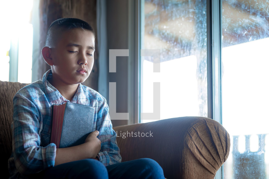 a boy embracing a bible, listening to the voice of God
