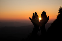 raised hands at sunset 