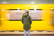 woman standing in front of a passing subway train 