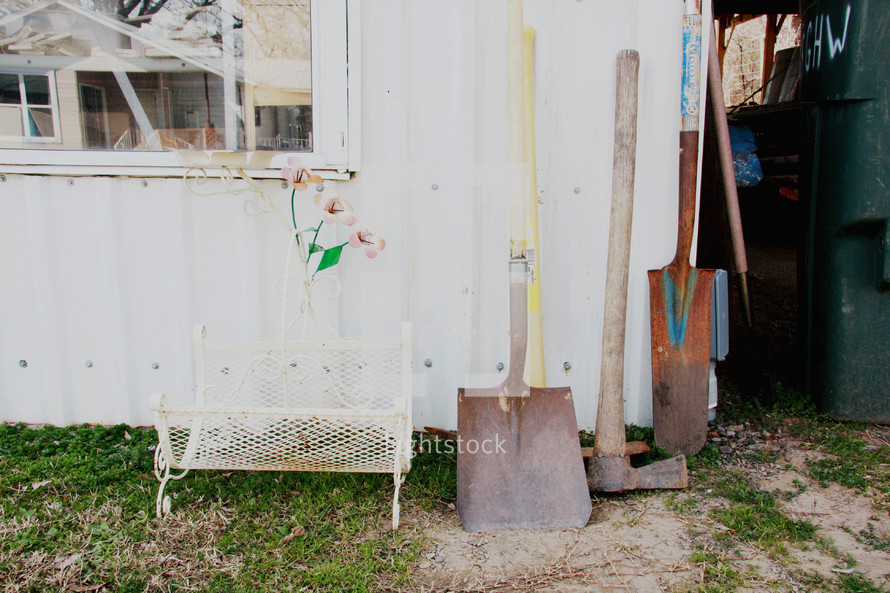 tools outdoors by a shed door 