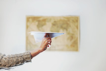 a woman throwing a paper airplane 