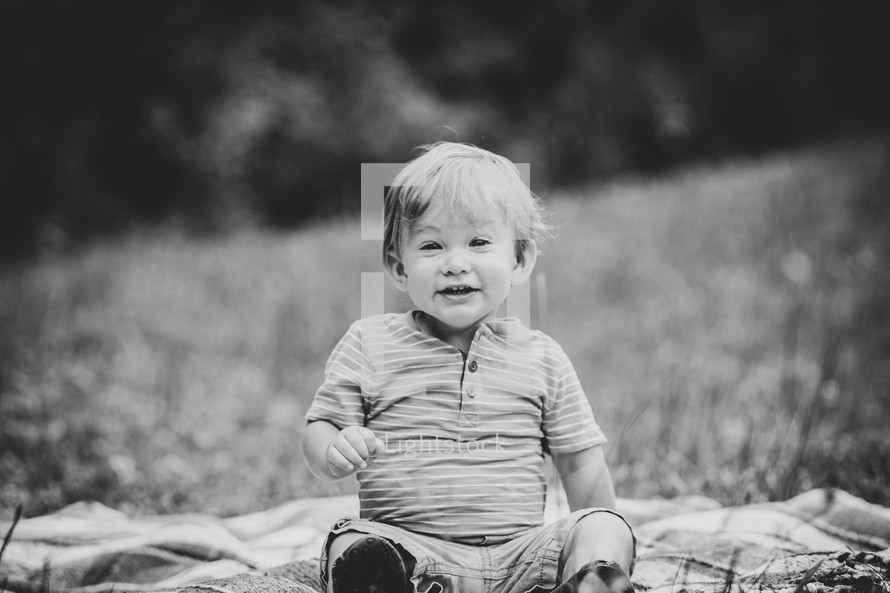 toddler sitting on a blanket in the grass