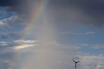 a rainbow in the sky above a wind turbine 
