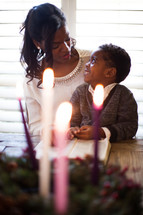 mother and son reading a Bible by an Advent wreath 