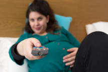 a pregnant woman watching tv 