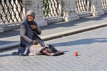 a woman begging on the streets in Rome 