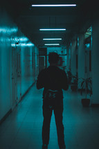 man standing in an illuminated hallway 