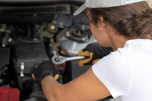 woman working on a car engine 