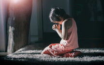 a girl kneeling in prayer 