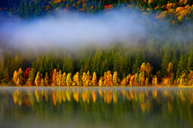 autumn landscape in the mountains with trees reflecting in the water at St. Ana's lake, Romania