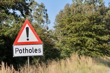 warning potholes sign