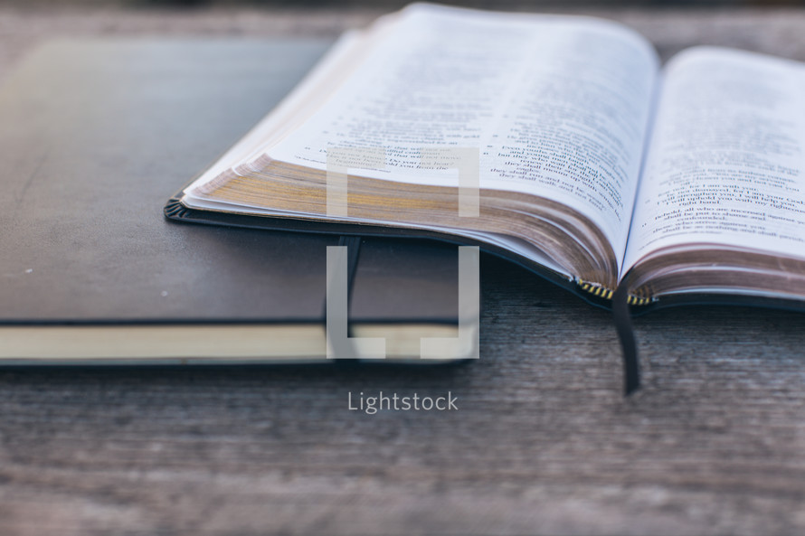 open Bible and journal on a wood table 