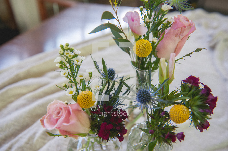 flowers in vases on a tablecloth 