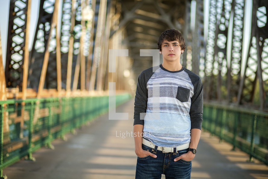 young man standing on a covered bridge 