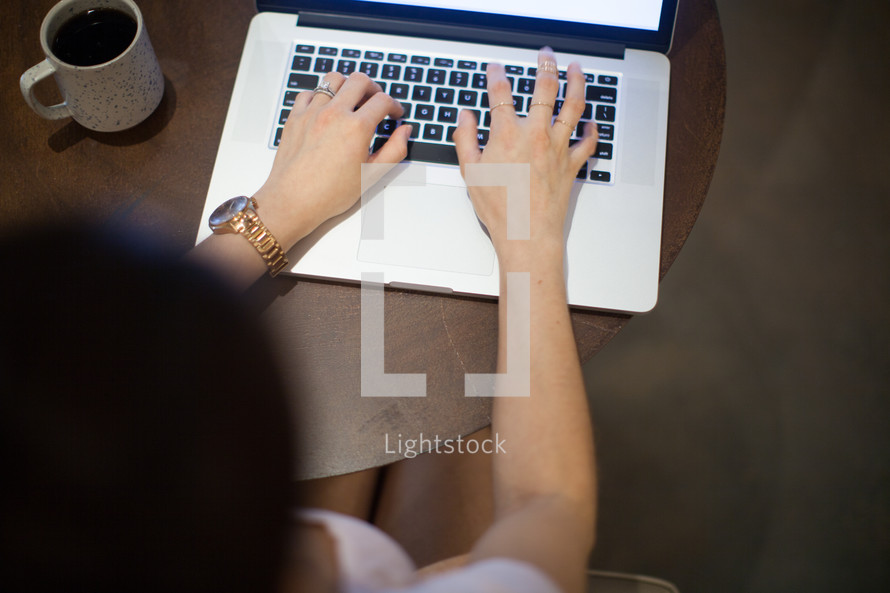 A woman sitting at a table working on the computer