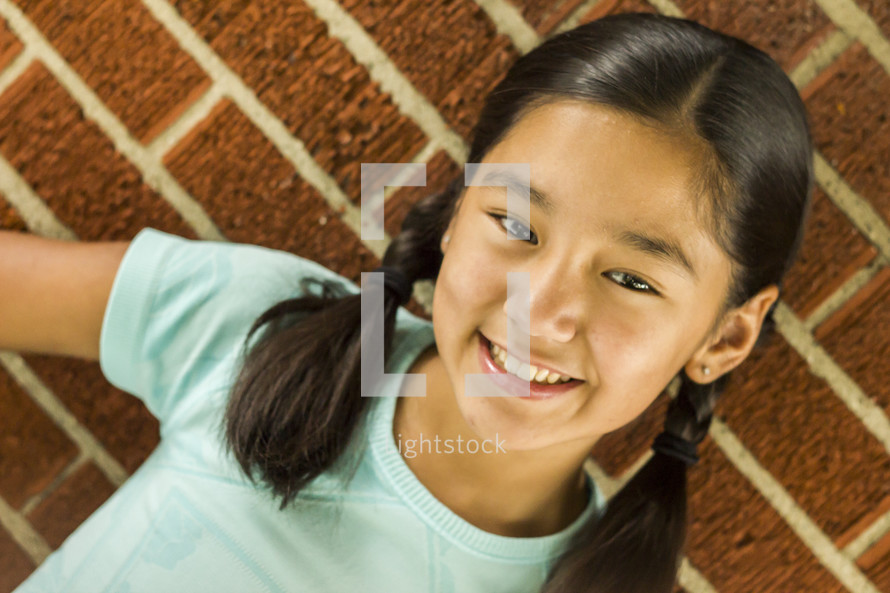a young smiling girl with pigtails 