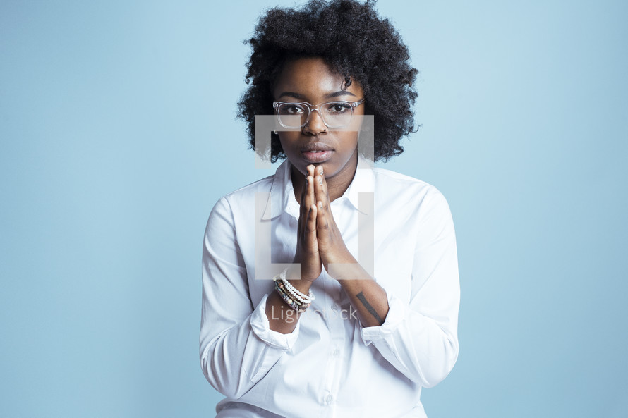 young African American female model posing with praying hands 