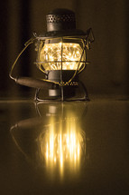 glowing lantern reflecting on wooden floor