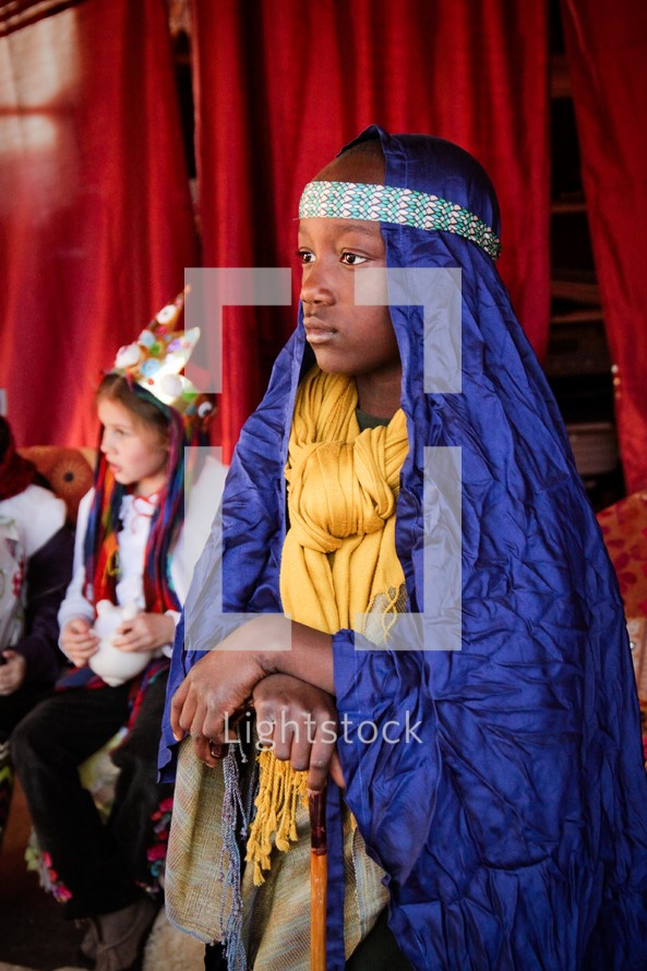 a boy child dressed as Joseph in a live nativity scene 