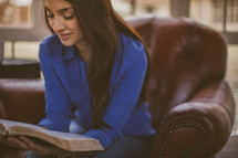 A woman sitting reading a Bible 