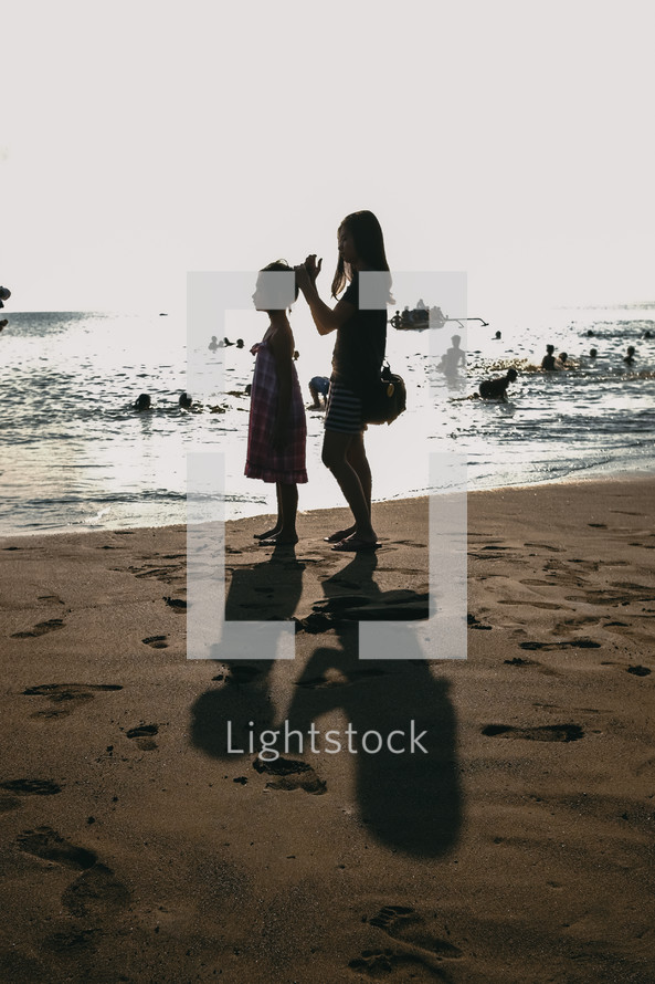 mother and daughter standing on a beach 