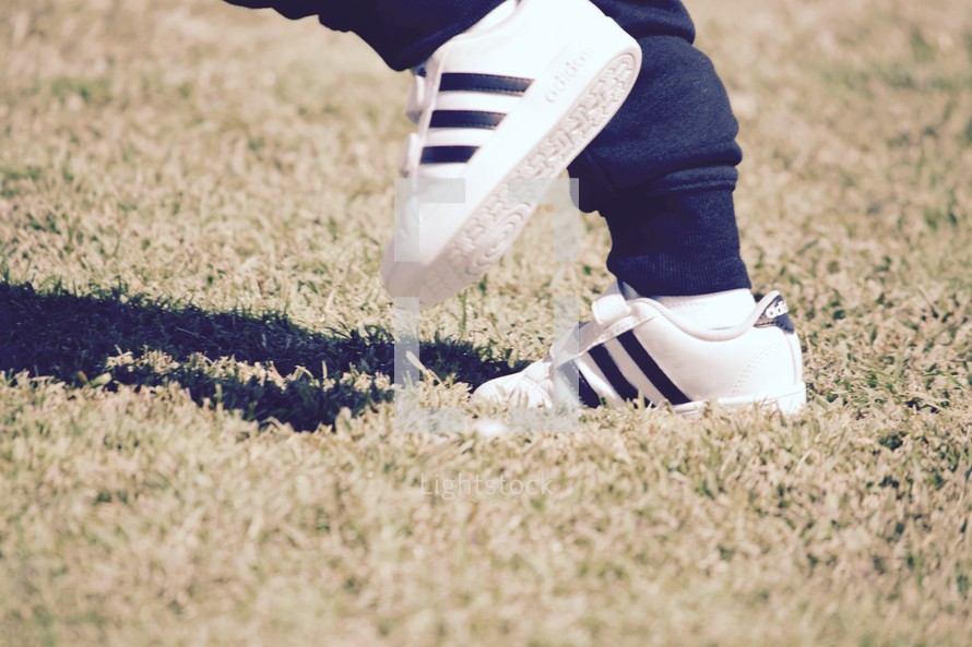 feet of a toddler running in sneakers 