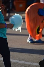 child with cotton candy at a festival 