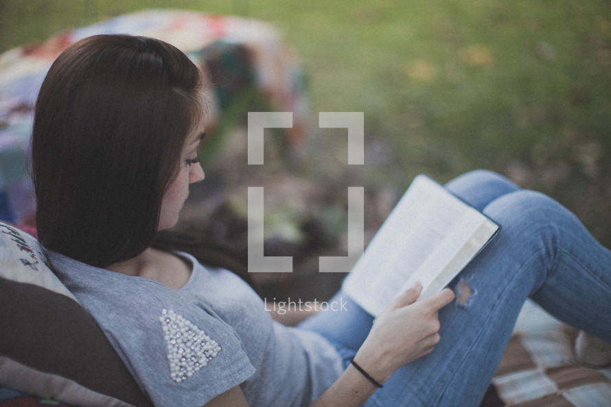 A young woman sitting and reading the Bible