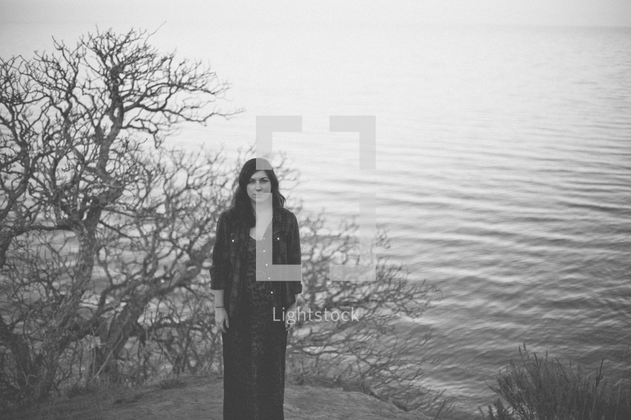 Woman standing by a lake.