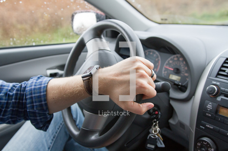 a man wearing a smartwatch driving a car 