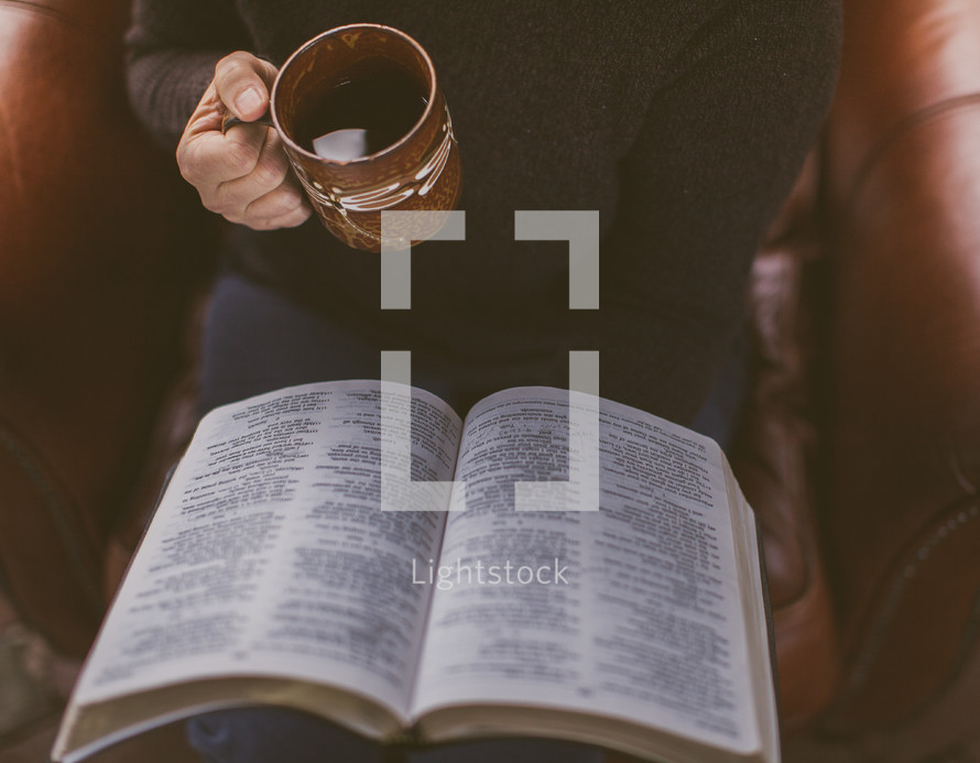 A woman reading the Bible and holding a coffee mug